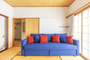 a blue couch with orange pillows in a room at Vaisala in Nozawa Onsen