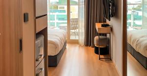 a hotel room with two beds and a balcony at Busan CONNECT Ocean Hotel in Busan