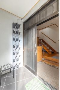 a pivot door in a garage with a bench and stairs at Kalik House in Nozawa Onsen