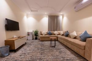 a living room with a couch and a tv at Rewaq Resident رواق ريزدنت in Medina