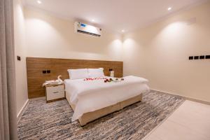 a bedroom with a large white bed and a desk at Rewaq Resident رواق ريزدنت in Medina