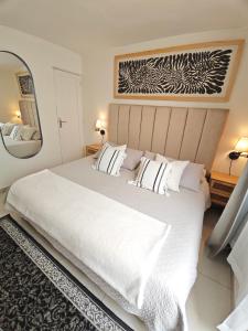 a bedroom with a large white bed and a mirror at Comfy Habitación en Puebla! in San Baltasar