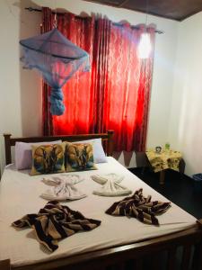 a bed with towels and shoes on top of it at Thisal Guest House in Polonnaruwa