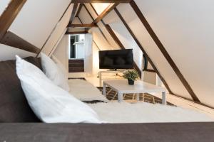 a room with a couch and a tv in a attic at Lil' Dutch Studio in Amsterdam