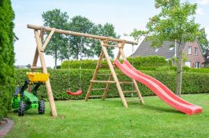 a playground with a slide and a swing at Birgits Huuske in Stedesdorf +35 photos