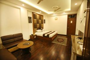 a hotel room with a bed and a couch at Hotel Parkway Deluxe in New Delhi