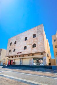 a large brick building on the side of a street at Rewaq Resident رواق ريزدنت in Medina