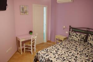 een slaapkamer met een bed, een bureau en een tafel bij Alla Bigattiera in Osimo