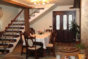 ein Esszimmer mit einem Tisch und einer Treppe in der Unterkunft Pensiunea Casa Cristina in Câmpulung Moldovenesc