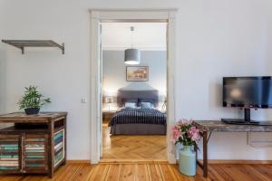 GreatStay Apartment - Paul Robeson Str. في برلين: غرفة نوم بسرير وطاولة مع تلفزيون