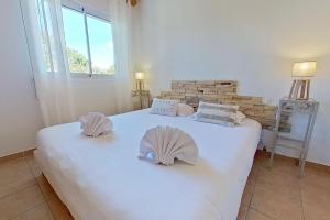 a large white bed in a room with a window at CALA CORSICA - Villas 5 Etoiles T5 Piscine privée - Villa T4 Piscine privée chauffée - Villa T3 Piscine partagée - Internet Fibre - Entièrement Climatisée à Lecci de Porto-Vecchio Cala Rossa in Lecci +68 photos