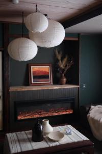a living room with a fireplace and two white lights at Sugi Crossroads in Myoko