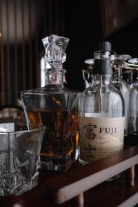 a bottle of whiskey and a glass on a table at Sugi Crossroads in Myoko