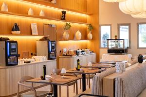 a restaurant with tables and chairs in a room at Golden Tulip Avignon Le Paradou in Avignon
