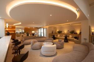 a large living room with couches and chairs at Golden Tulip Avignon Le Paradou in Avignon
