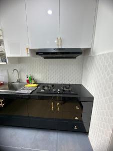 a kitchen with a black counter top and a sink at Botaniqa Residence in Puchong