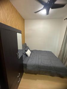 a bedroom with a black bed and a dresser at Botaniqa Residence in Puchong