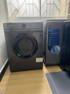 a washing machine is sitting on a floor at Botaniqa Residence in Puchong