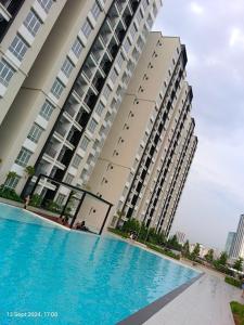 a swimming pool in front of a large building at Botaniqa Residence in Puchong +3 photos