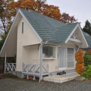 a small white house with a gray roof at Sun Terrace Hakone in Hakone