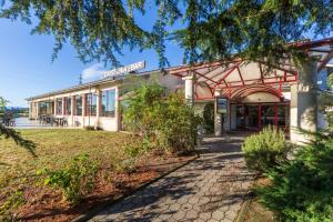 un bâtiment avec un panneau à l'avant dans l'établissement Aliotel, à Cazères-sur-lʼAdour