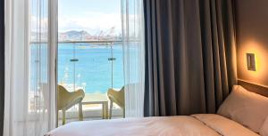 a hotel room with a bed and a view of the ocean at Busan CONNECT Ocean Hotel in Busan