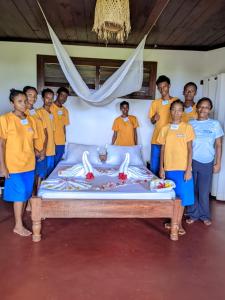 a group of people standing around a bed at WINGS HOTELS in Nosy Be