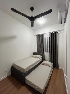 two beds in a room with a ceiling fan at De' Moysis Homestay in Batu Caves +8 photos