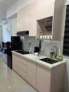 a white kitchen with a sink and a stove at De' Moysis Homestay in Batu Caves