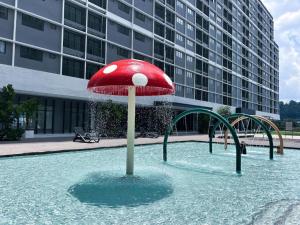 a red umbrella in the water in front of a building at De' Moysis Homestay in Batu Caves