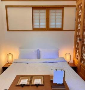 a bedroom with a white bed with a wooden table at 응정헌 in Seoul