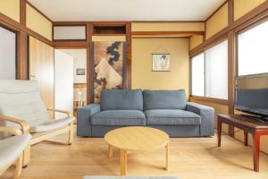 a living room with a blue couch and a table at James House in Nozawa Onsen