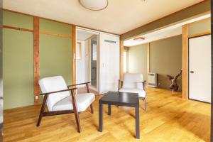 a living room with two chairs and a table at James House in Nozawa Onsen