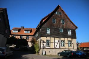 een groot houten huis met auto's voor het huis bij Ferienappartement Archimedes in Walkenried