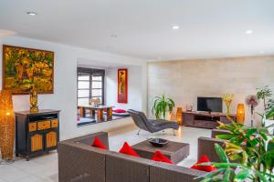 a living room with a couch and a tv at Villa Kubu Pratiwi - Villa 2 in Canggu