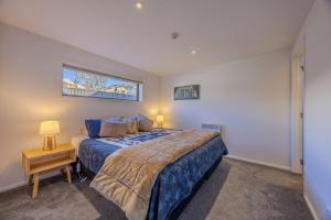 a bedroom with a king sized bed and a window at Aspiring View Apartments - Modern & Stylish 3-BRM, 3-BTH - 2 Min Walk to Lake & Town in Wanaka