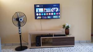 a room with a fan and a tv at palm ridge apartment Diani beach in Diani Beach