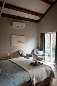 a bedroom with two chairs and a large bed at Sea You Soon in Callantsoog