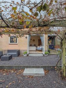 a brick house with a living room and a bedroom at Sea You Soon in Callantsoog