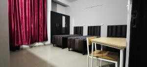 a room with a red curtain and a row of benches at Homely Space PG in Noida