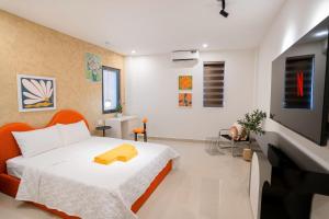a bedroom with a white bed and a television at Khách sạn Mona in Dĩ An +67 photos