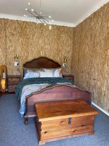 a bedroom with a bed with a wooden bed frame at Olivias Cottage in Knysna