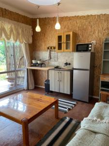 a kitchen with a table and a white refrigerator at Olivias Cottage in Knysna +13 photos