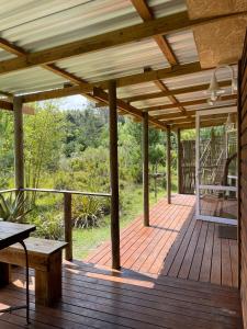 a wooden deck with a table and a bench on it at Olivias Cottage in Knysna