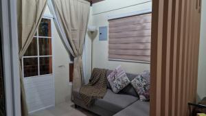 a living room with a couch and a window at Pool of Siloam with tiny house in Bangad