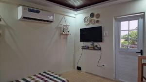 a living room with a flat screen tv on the wall at Pool of Siloam with tiny house in Bangad