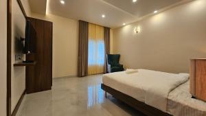 a bedroom with a bed and a chair in it at Stellar 23 Resort in Whitefield +17 photos