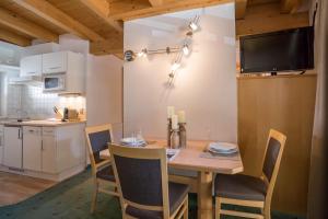 Apart Reinstadler في سولدن: مطبخ وغرفة طعام مع طاولة وكراسي خشبية