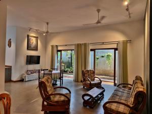 a living room with chairs and a couch and a tv at Mervins & Indus Residence in Colombo