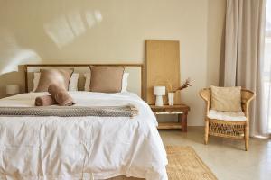 a bedroom with a large bed and a chair at Kokon Boutique Guesthouse in Somerset West